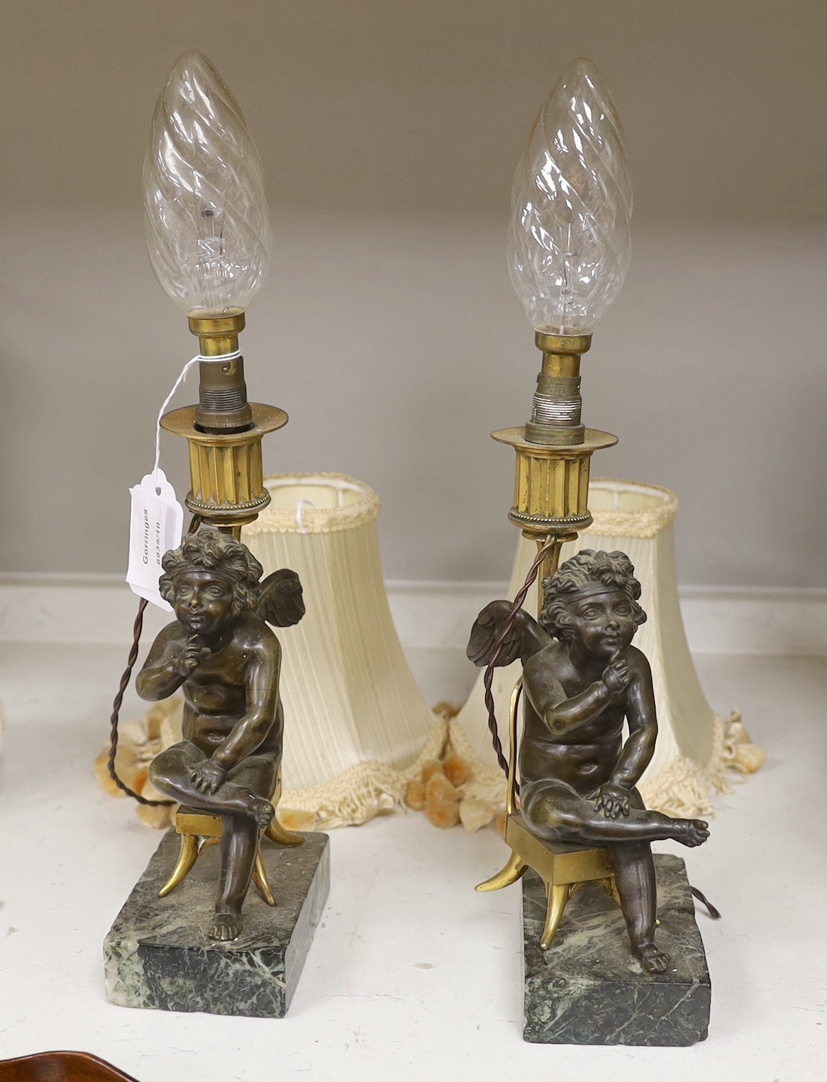 A pair of late 19th century figural bronze and ormolu cherub candlesticks, converted to lamps, 26cm tall excluding bulb